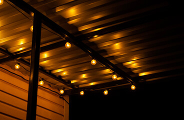 Garlands of yellow light bulbs in the night. Christmas mood