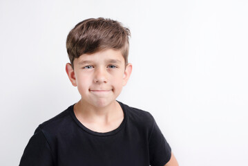 A young boy is upset, trying to smile, but he was insulted at school and is in a bad mood. A young boy is confident in himself but not confident in his friends