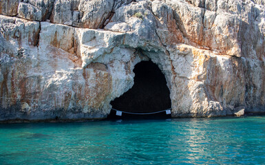Cave in the cliff, in the sea. There is a sign saying in Turkish, 