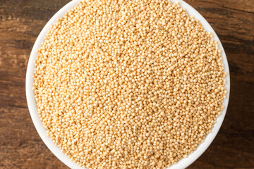Amaranth seeds in bowl on rustic wooden table. Top view