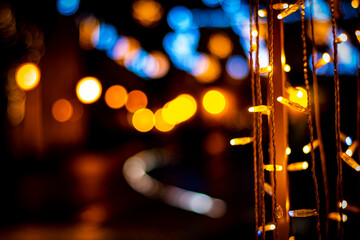 Colorful christmas lights with blurred street lights in the background at night