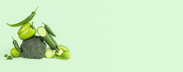 Different vegetables on green background with space for text