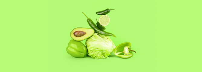 Composition with different fresh vegetables on green background