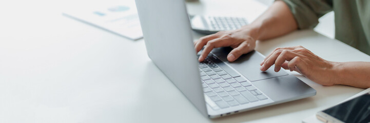 Businesswoman using laptop with technology to typing and working about calculation tax in office