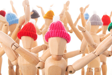 Crowd wooden mannequins with winter hat - 667245331