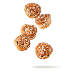 Fresh baked cinnamon buns flying falling isolated on white background. Traditional swedish sweet pastry kanelbulle.