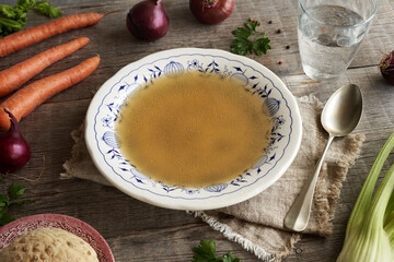 Chicken soup or bone broth in a vintage plate