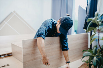 man assembling furniture wooden cabinet at home