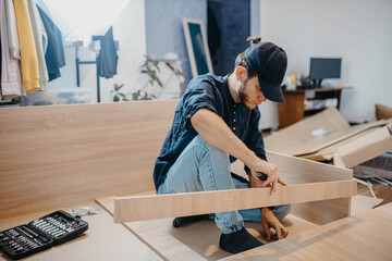 man assembling furniture wooden cabinet at home