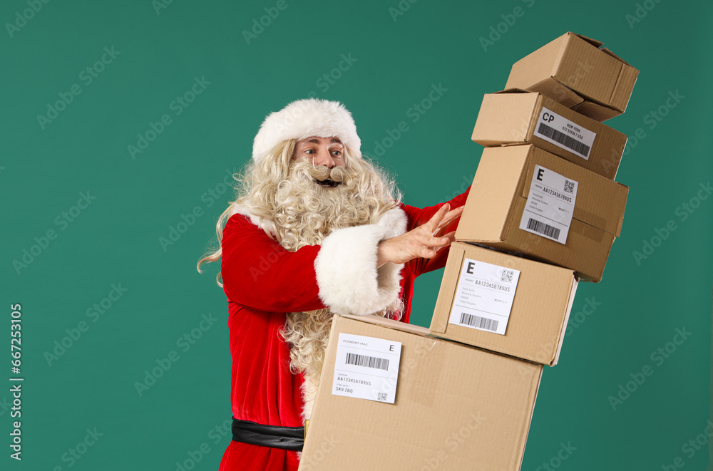 Wall mural santa claus with stack of falling parcels on green background