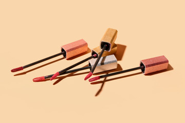 Different lipstick brushes on beige background