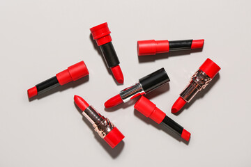 Different stylish red lipsticks on light background