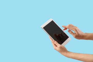 Woman with blank tablet computer on blue background