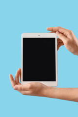 Woman with blank tablet computer on blue background
