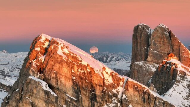 Veduta aerea della luna tra le cime innevate delle montagne delle Dolomiti