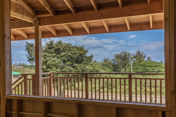 New Home construction with wood, view of deck railing and yard with trees