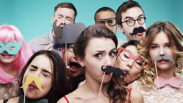 Party celebration, happy and friends with mustache, crazy portrait and social on blue studio background. Funny smile, group photobooth and people with props for a photo at an event to celebrate