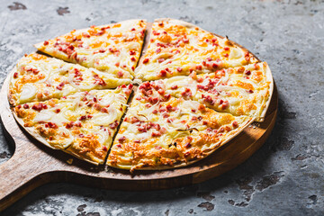 Traditional French dish tarte flambee with cream cheese, bacon and onions. Flammkuchen from Alsace...