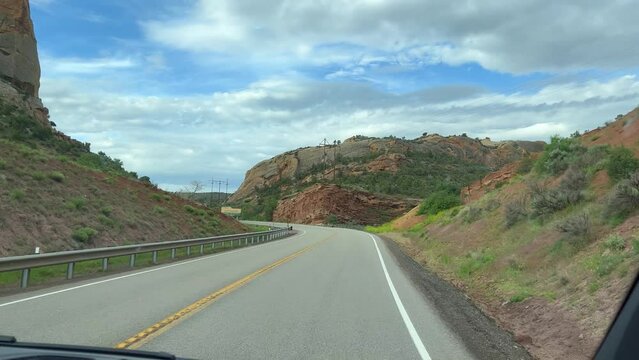 Driving through Flaming Gorge area in Wyoming and Utah with the Green River and beautiful mountains on a cloudy day.