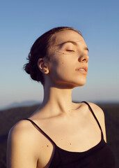 portrait of a beautiful carefree woman against a background of blue sky and mountains in the distance