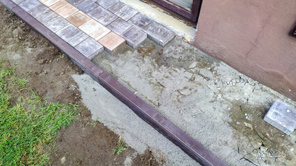  Close-up shot of a worker expertly laying paving stones during a renovation.