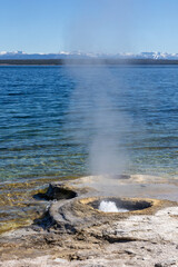 Geyser along lake in West Thumb Basin in Yellowstone National Park