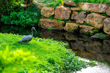 Metal bird sculpture by river