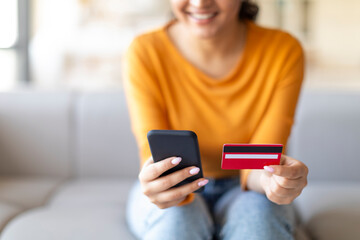 Online Banking. Closeup Of Woman Using Smartphone And Credit Card At Home