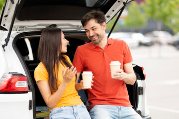 Fototapeta na wymiar Loving millennial couple have break during road trip, drinking coffee