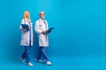 Professional medical team doctors walking towards copy space