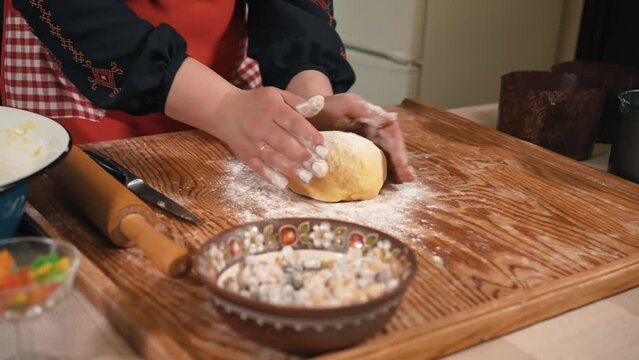 Female hands preparing dough for Easter bread in the kitchen, dough with flour close-up. Assembling the dough for baking Easter bread in the oven. Cooking paska, desserts in the oven at home. Fluffy