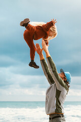 Father throws child up in the air happy family lifestyle outdoor dad and daughter playing together...