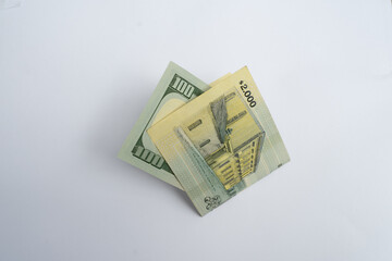 A 2,000 Uruguayan Pesos Banknote Next to a 100 US Dollar Bill, Comparing Currencies. Economic Concept.