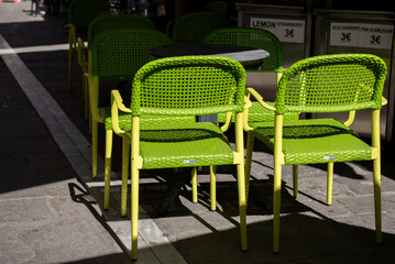 Green chairs and table in restaurant on the street