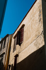 Fototapeta na wymiar Mediterranean style urban building wooden jalousie in sunshine, blue sky