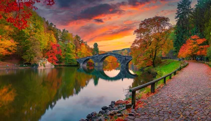 Foto auf Acrylglas Rakotzbrücke fantastic autumn landscape amazing sunset with colorful sky in azalea and rhododendron park kromlau rakotz bridge rakotzbrucke devil s bridge in kromlau saxony germany