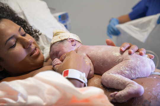 Newborn baby resting on mother's chest in hospital