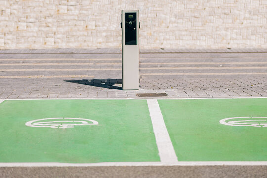 Electric car charger sign on ground near charger station