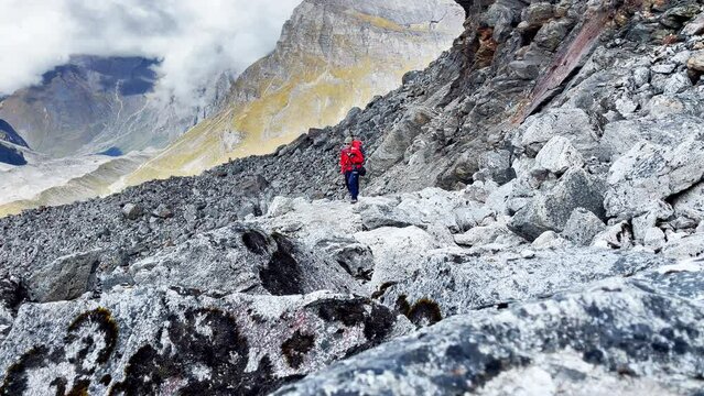 Two expedition members with backpacks together following Makalu Barun Park trekking route near Khare. Mera peak climbing acclimatization walk. Backpackers using trekking poles, enjoying valley view.