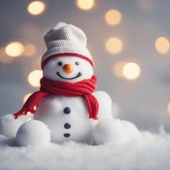 Obraz premium Cute snowman wearing red scarf on a snowy area and bokeh light background