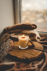Burning candle in home interior, autumn aesthetics