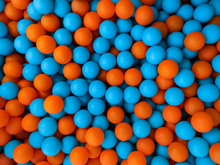 Blue and orange balls in a children's ball pit. Background. Example of the complementary colours blue and orange.