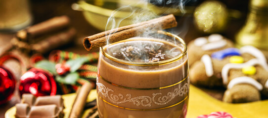 hot chocolate with steam or smoke, Christmas drink, with gingerbread man in the background, Christmas dessert