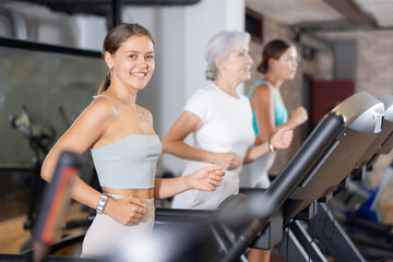Fototapeta na wymiar Sporty woman doing cardio workout running on treadmill at fitness center