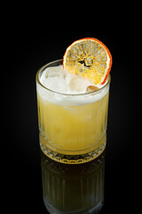 Whiskey Sauer. A sauer cocktail based on whiskey with citrus juice and sweetening ingredients. A drink containing whisky, lemon juice and sugar in a glass on a dark background with a reflection