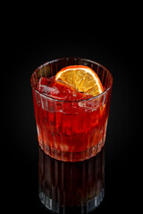 Negroni. Aperitif cocktail based on gin and vermouth.  Drink in a glass on a dark background with reflection