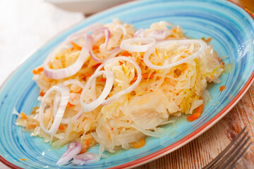 Plate with traditional Russian salted cabbage sauerkraut with onion, nobody