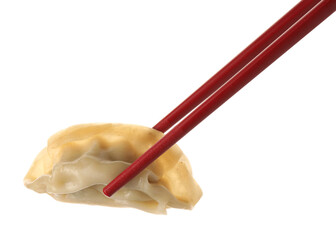 Chopsticks with delicious gyoza (asian dumpling) isolated on white