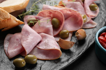 Tasty ham with olives, garlic and bread on table, closeup