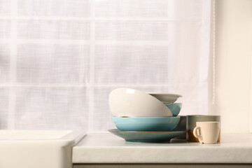 Clean tableware on light countertop in kitchen, space for text